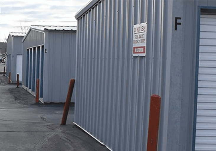 A row of storage buildings with signs on them.